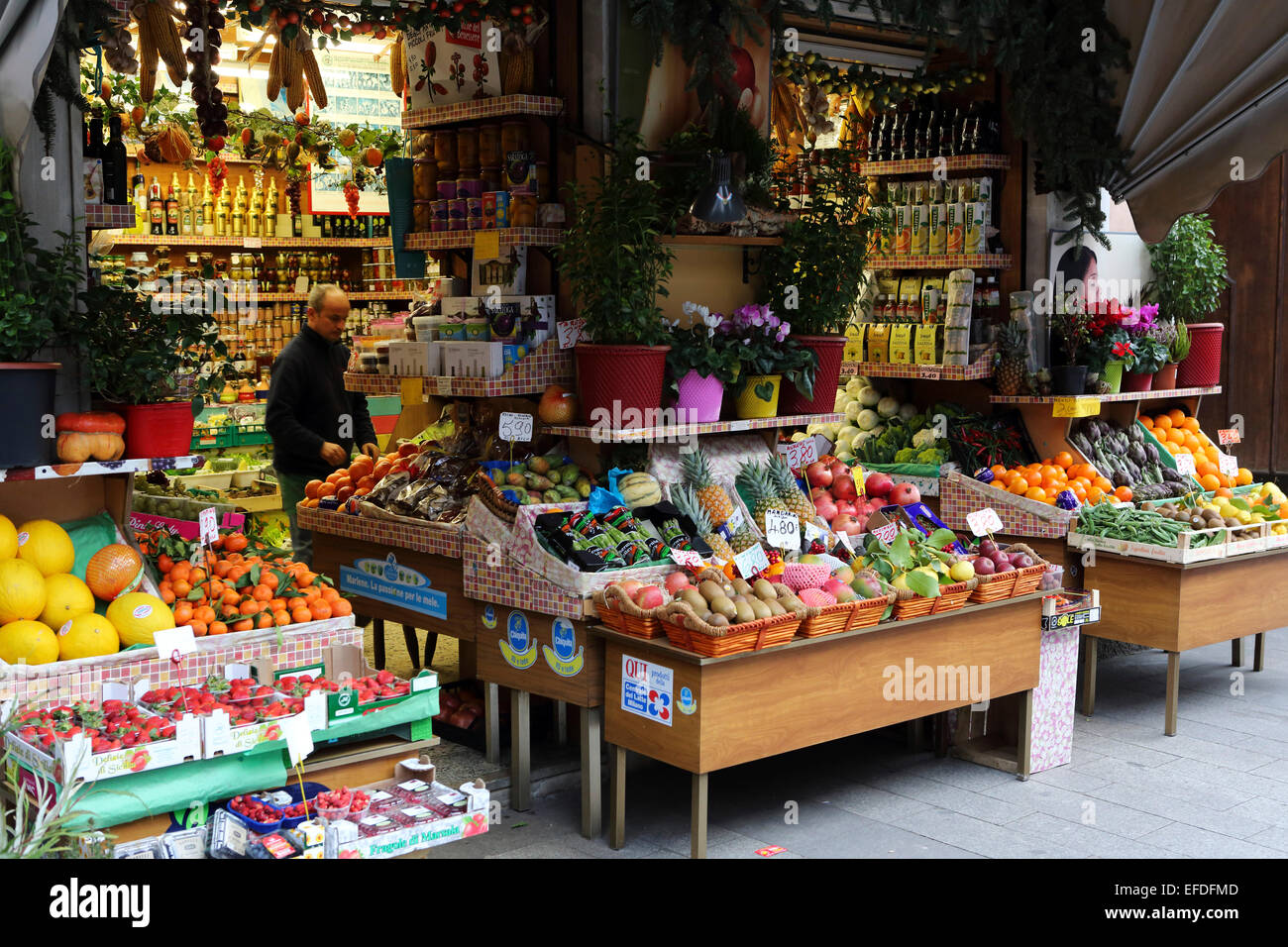 A grocery store in central Milan, Italy. The shop sells fruit, vegetables  plus items including olive oil and tinned goods Stock Photo - Alamy