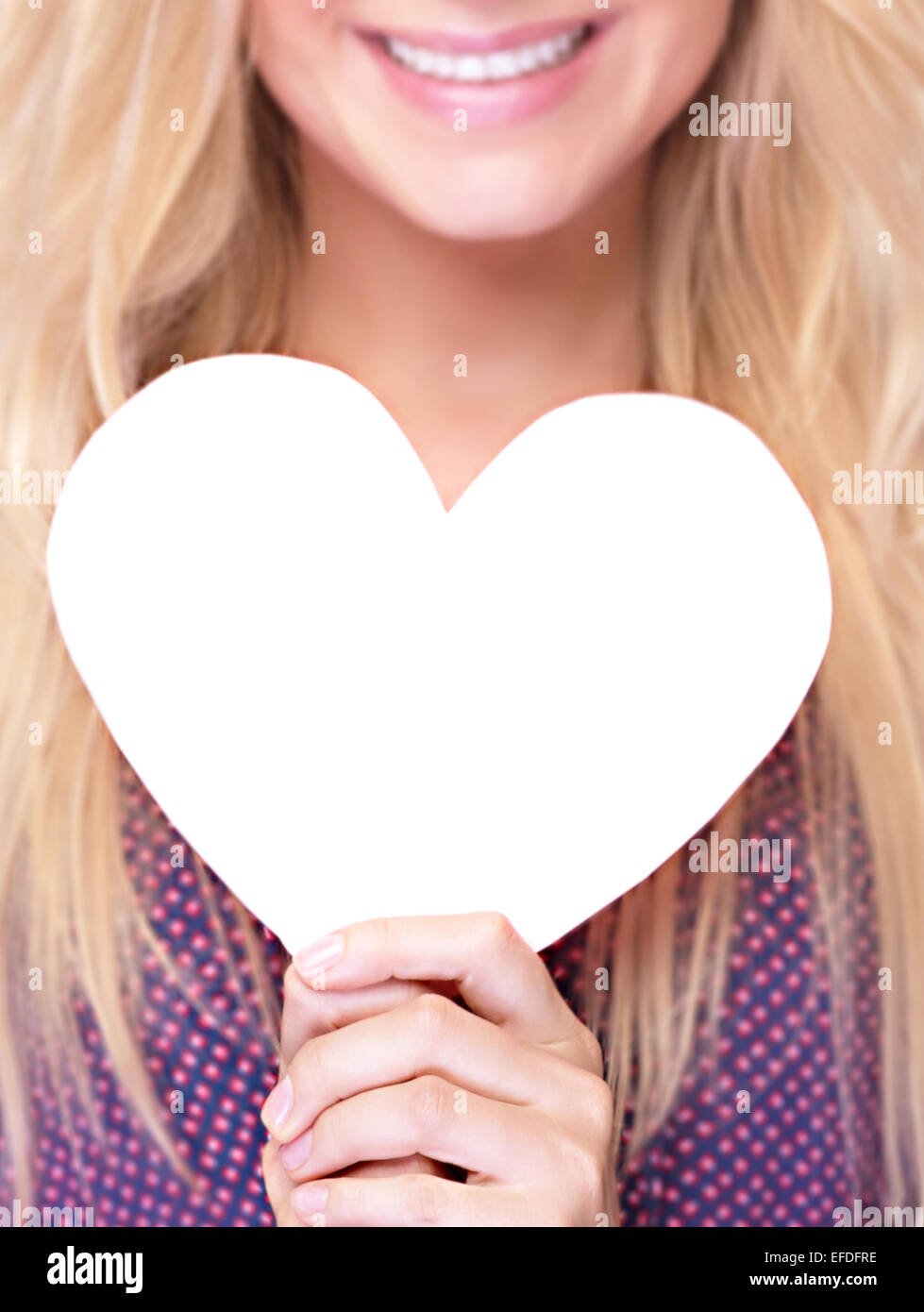 Closeup photo of happy smiling woman holding in hands white paper heart shaped greeting card, healthy lifestyle Stock Photo