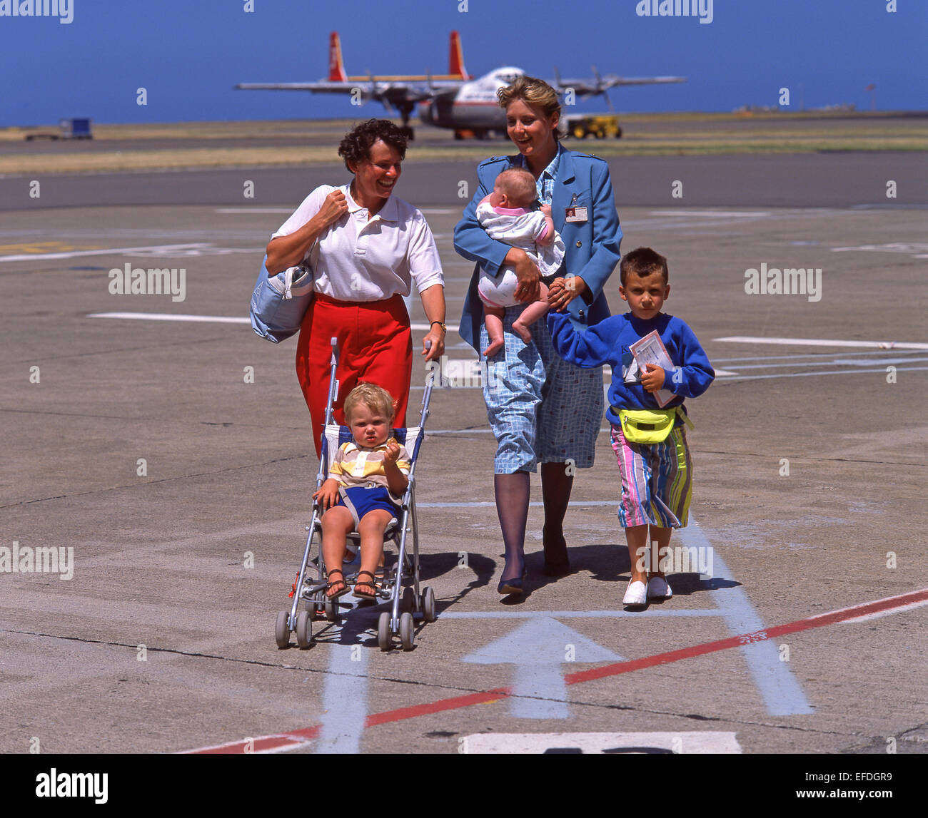 Family escorted on tarmac, Auckland International Airport, Mangare, Auckland, Auckland Region, North Island, New Zealand Stock Photo