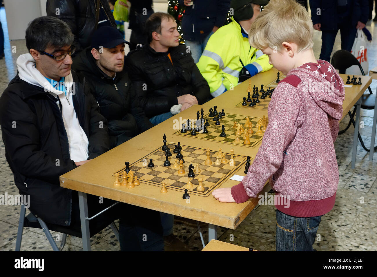 10 years old boy plays simultaneous chess game with 4 adult participants .  Nordstan, Göteborg,  Gothenburg, Sweden Stock Photo