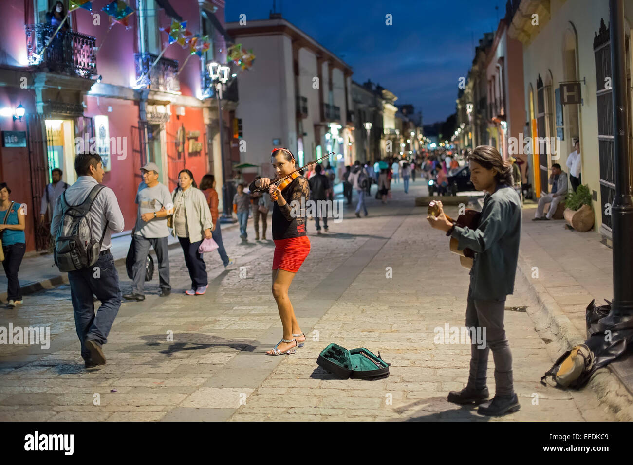 Oaxaca, Mexico - A woman and man play the violin and guitar for tips on a pedestrian street. Stock Photo