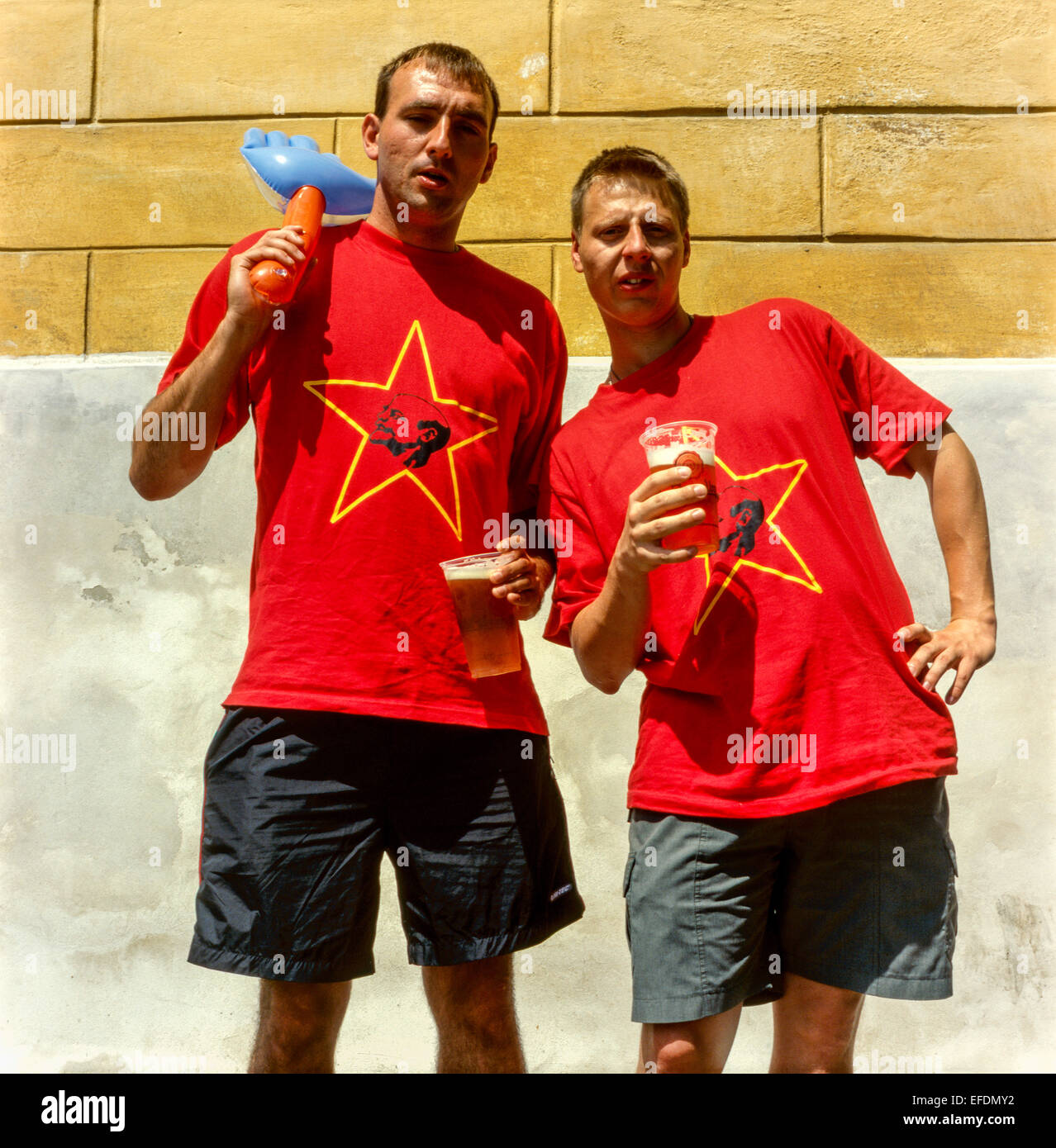 Two men with beer and a retro t-shirt with communist symbols Lenin star hammer Czech Republic young friends drink Stock Photo