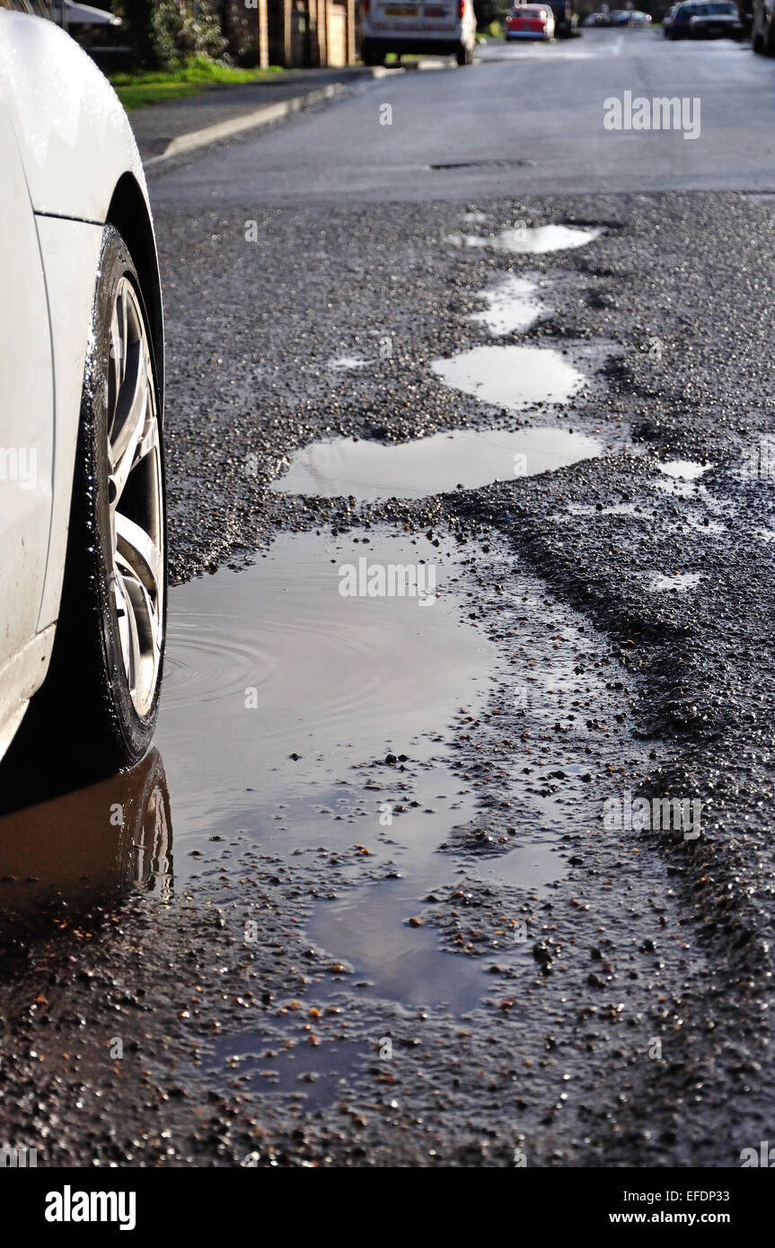 Wet potholes in road, Stanwell Moor, Surrey, England, United Kingdom Stock Photo