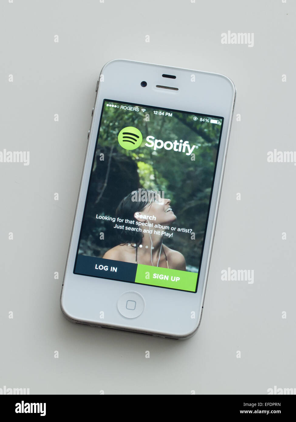 A view of the logo and homescreen of the Spotify app on an Apple iPhone 4. Stock Photo