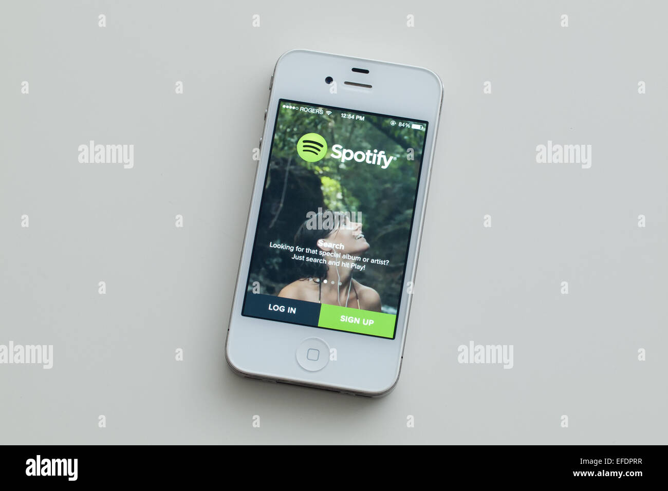 A view of the logo and homescreen of the Spotify app on an Apple iPhone 4. Stock Photo