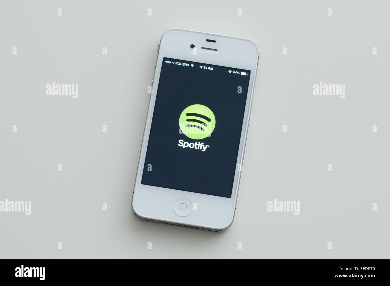 A view of the logo and homescreen of the Spotify app on an Apple iPhone 4. Stock Photo