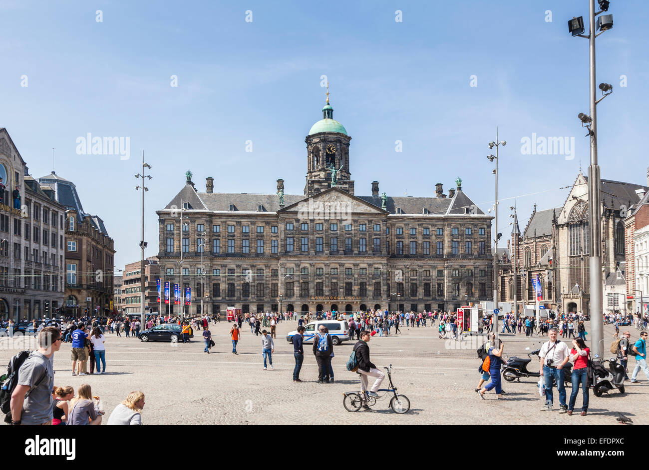 The iconic Royal Palace of Amsterdam, a landmark in Amsterdam, Netherlands with a crowd of tourists in Dam Square on a sunny day with a blue sky Stock Photo