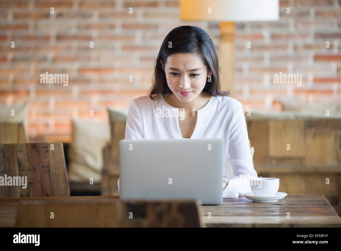 Young woman using laptop in cafe Stock Photo - Alamy