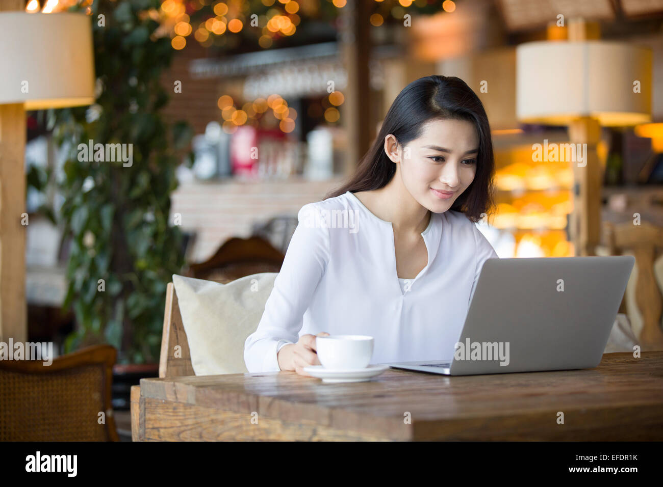 Young woman using laptop in cafe Stock Photo - Alamy
