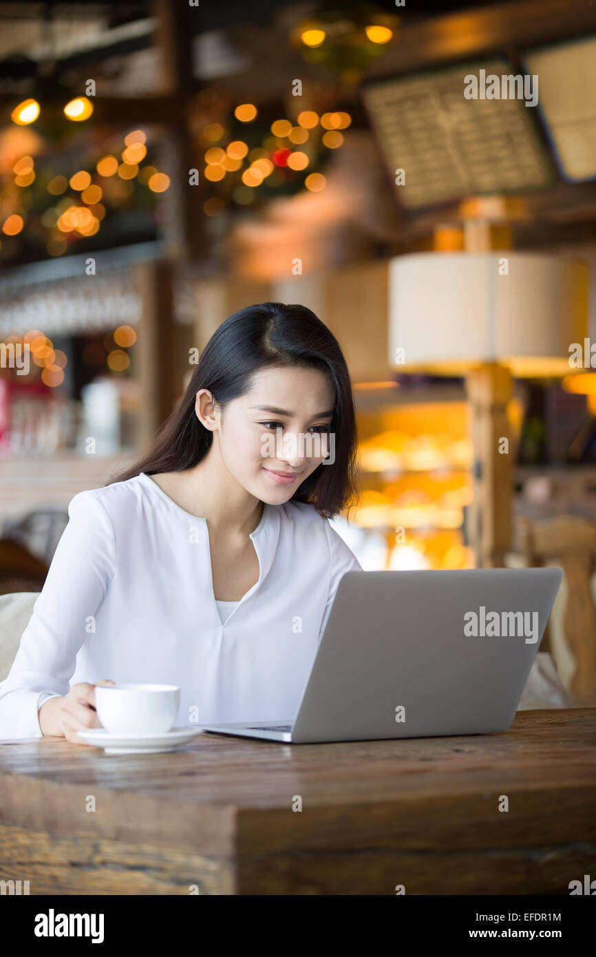 Young woman using laptop in cafe Stock Photo - Alamy