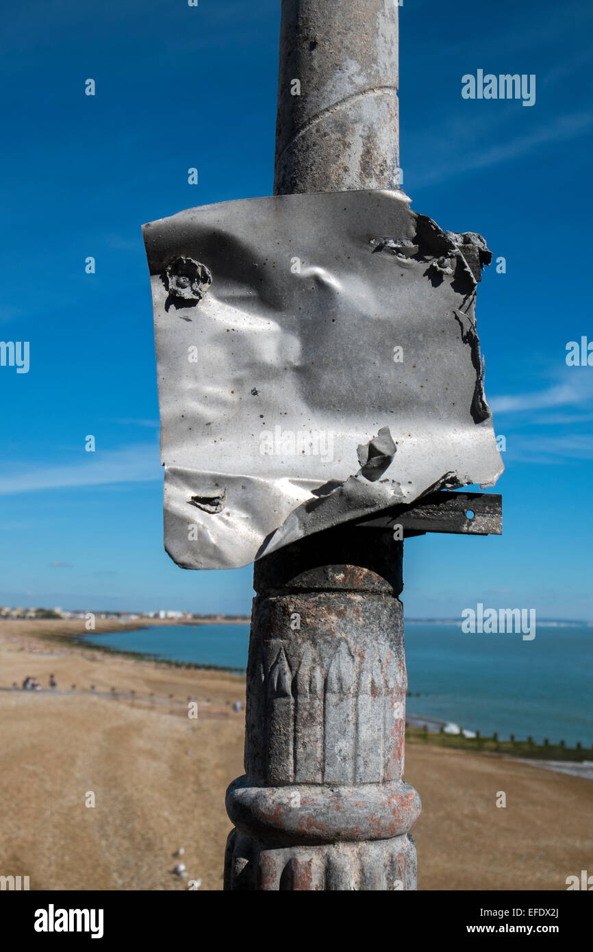 Fire damage to a metal sign on a lamp post Eastbourne Pier Sussex UK Stock Photo