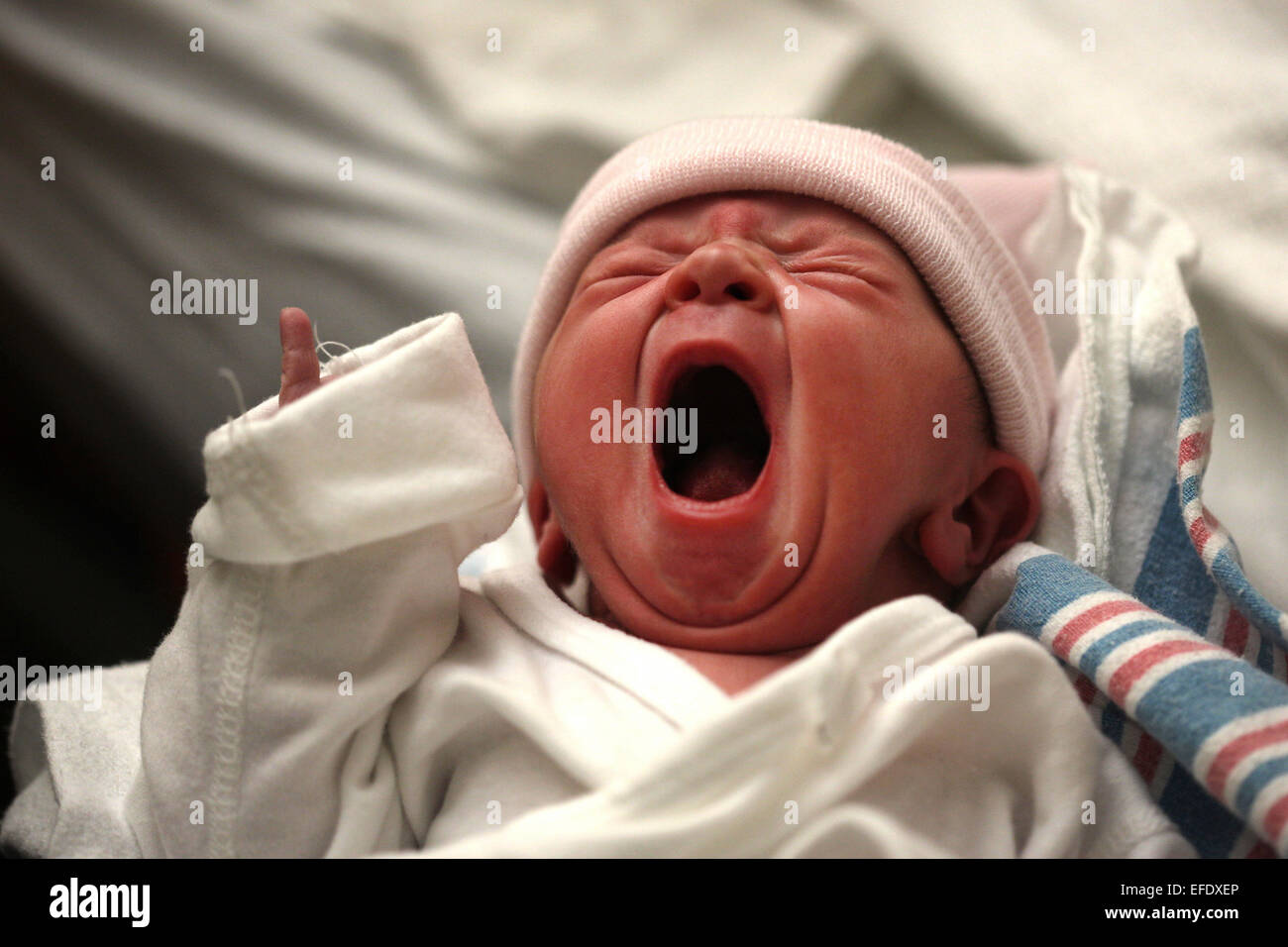 A newborn baby yawns after birth in a hospital environment. Photo Tim