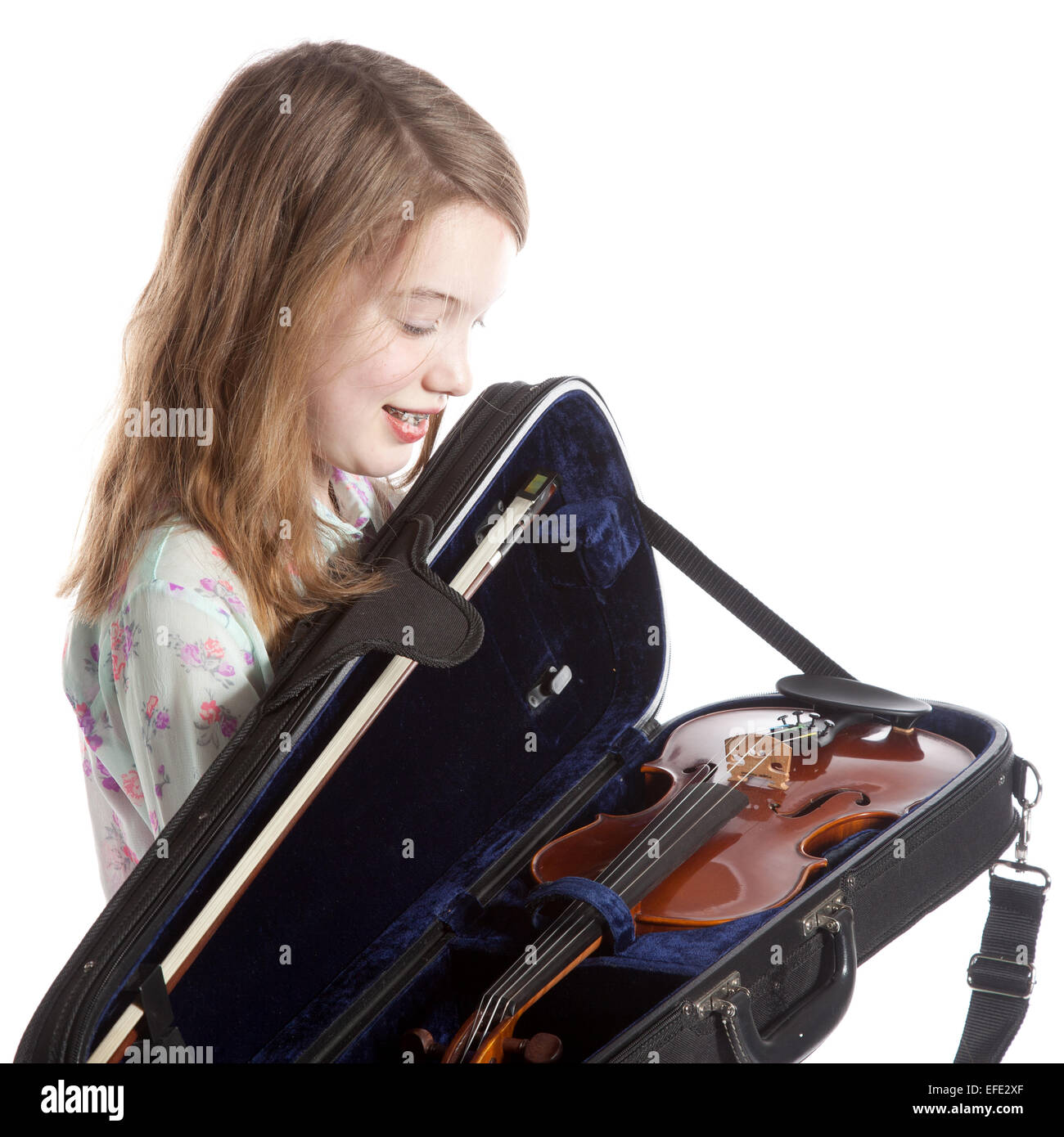 young girl stands in studio against white background with violin in ...