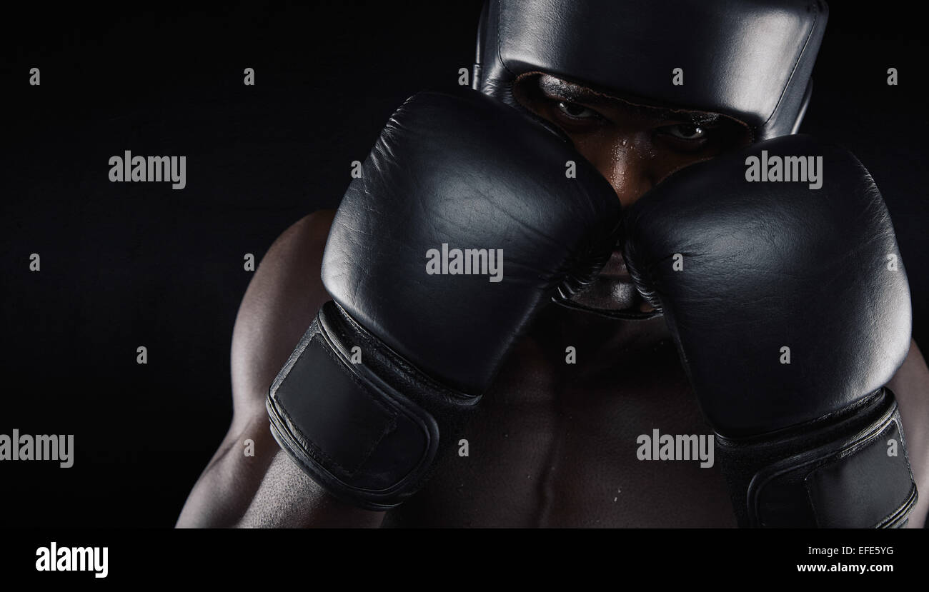 African american boxer wearing protective gear against black background