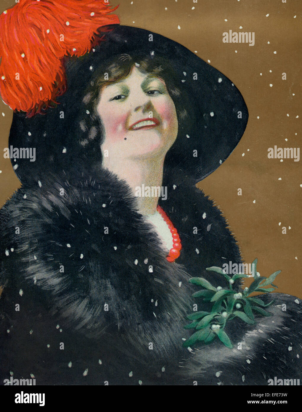 Christmas 1911 a Illustration shows snow falling on a beautiful woman wearing a large hat, holding mistletoe. Stock Photo