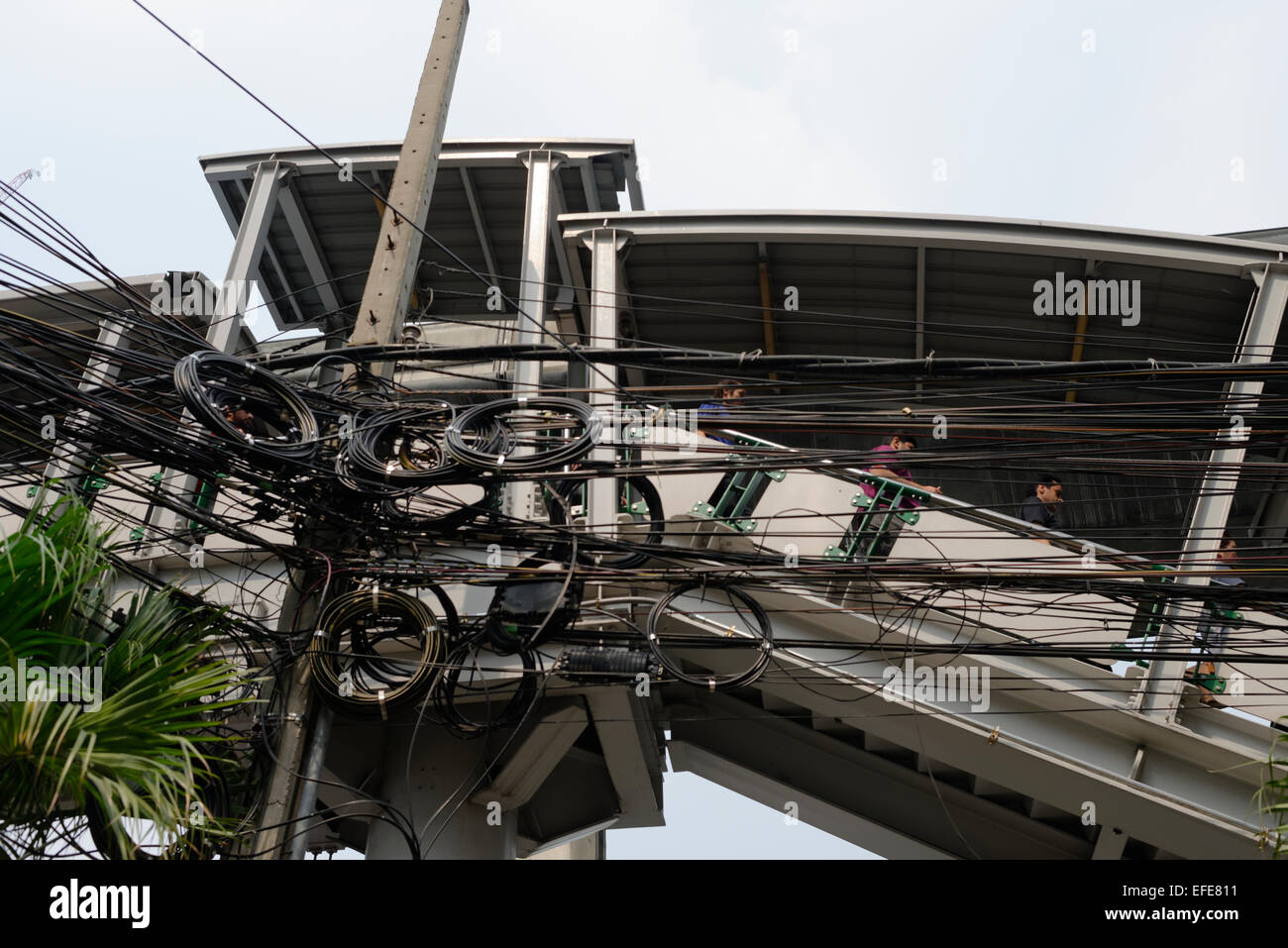 Power telecoms telephone telecommunication electricity cables hanging in Bangkok above the streets. Stock Photo