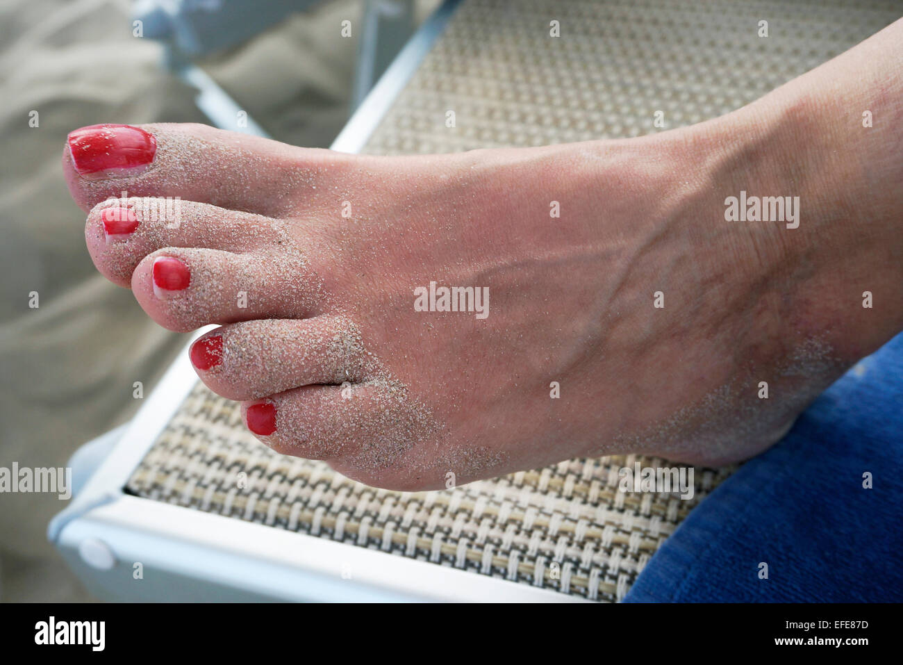 Foot with red nails of woman lying on sunbed Stock Photo Alamy