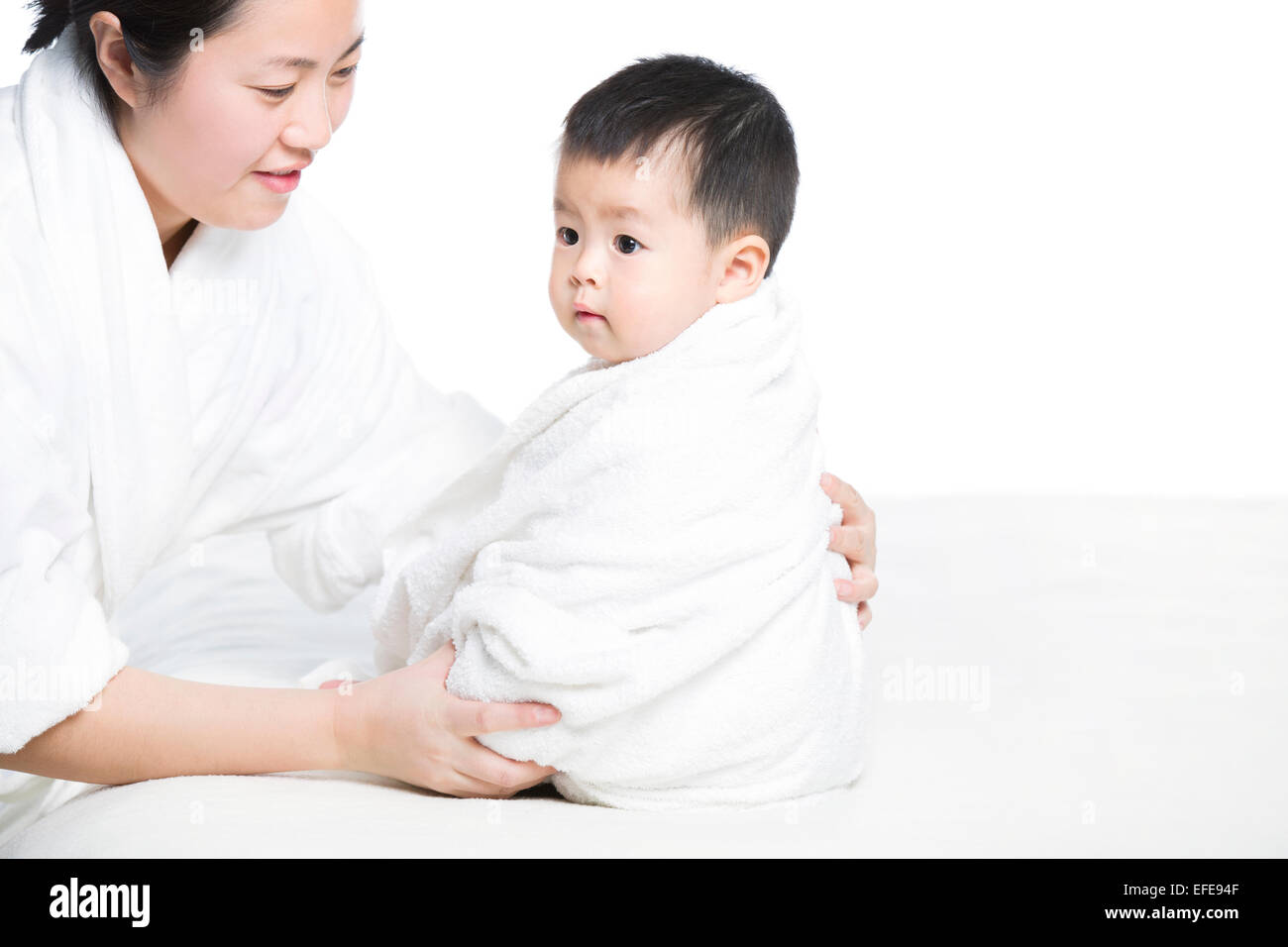 Mother wrapping baby in blanket Stock Photo Alamy