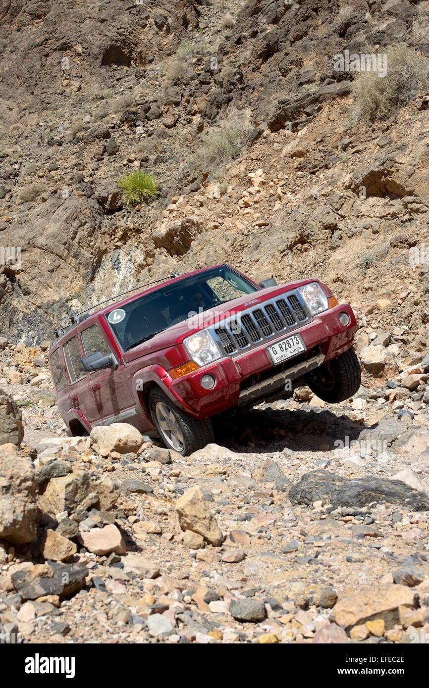 A Dubai-registered Jeep Commander 4x4 vehicle negotiates a rocky track in the desert interior of the Sultanate of Oman. Stock Photo