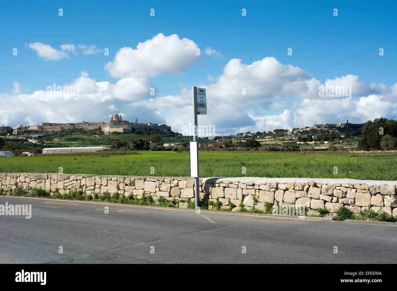 A bus stop named Snajja close to the Ta'Qali crafts village. Across the fields on the hill is the silent city of Mdina. Stock Photo