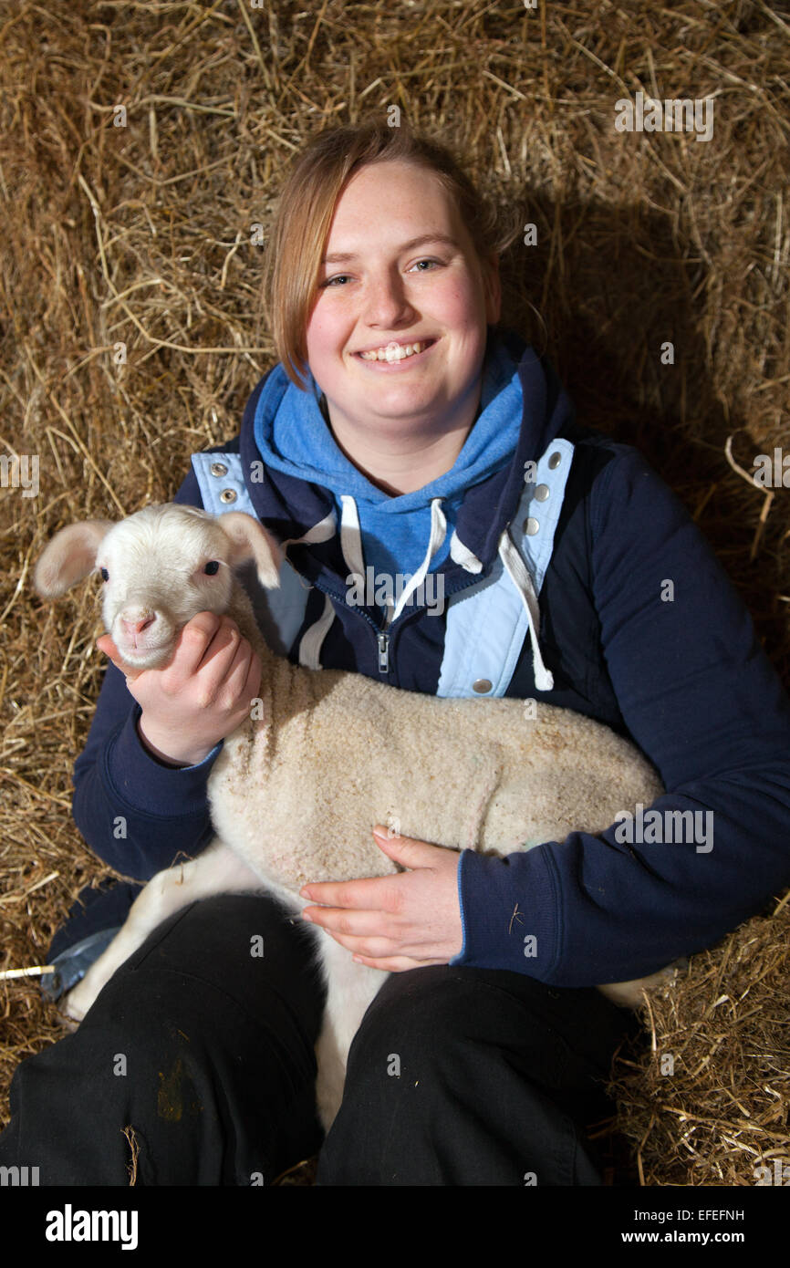 Blackpool, Lancashire, UK. 2nd February, 2015. Abi Harris, 18 with a two day old, BritishMilk winter born lamb, orphan at Parr’s Farm. The new born lambs at Farmer Parr’s Animal World are christened Keith and Colin. They were adopted from a local sheep farmer who had 2 orphan lambs, a just-born triplet that required bottle feeding. The farm park in Fleetwood sometimes takes in ‘pet’ lambs at this time of year so that visiting children can help to feed them.  Credit:  Mar Photographics/Alamy Live News Stock Photo