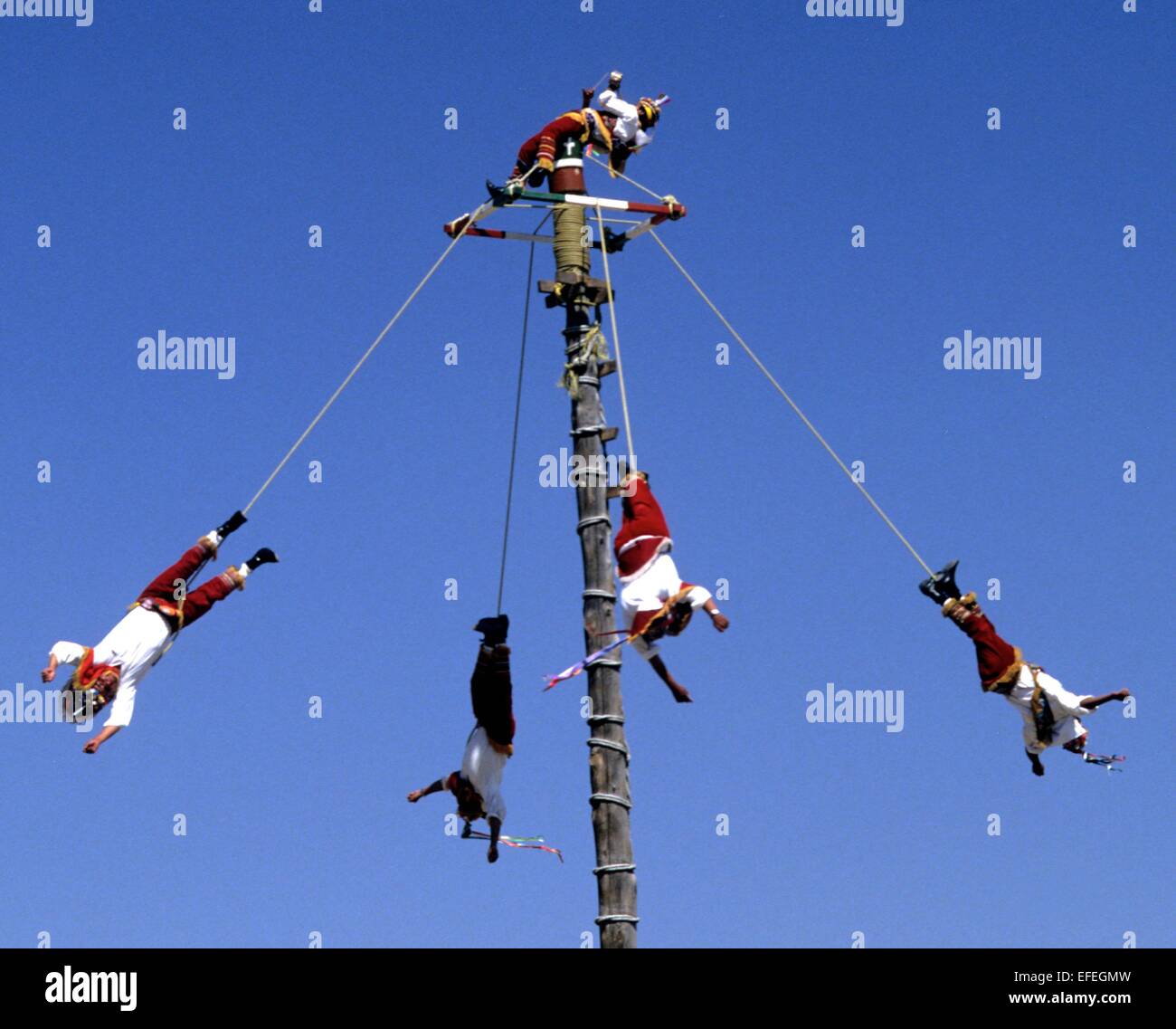Mexico - Totonac Indians perform intricate weaving dance routines on top of a pole nearly 100 feet up in the air. Stock Photo