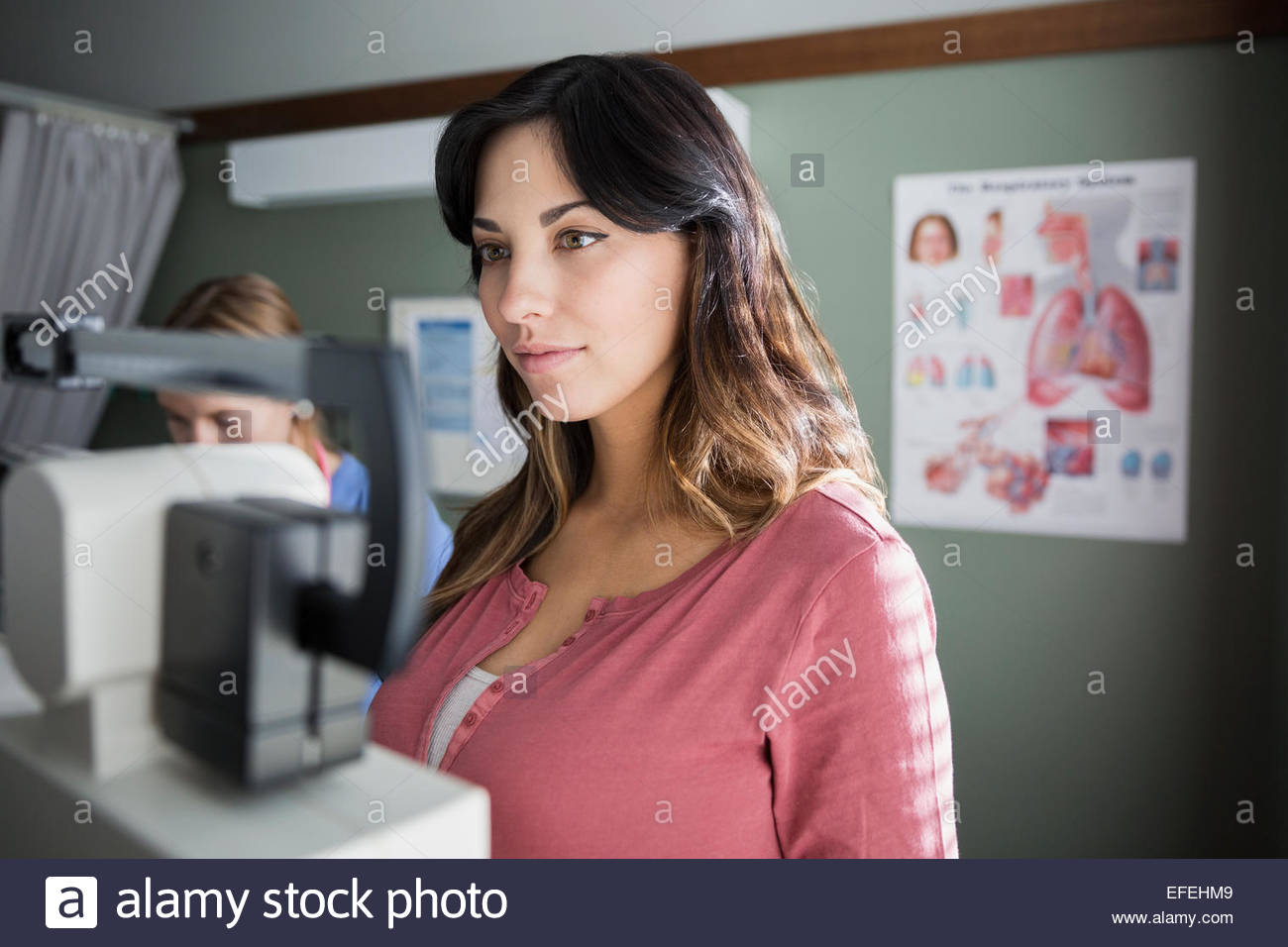 Woman on weight scale in examination room Stock Photo