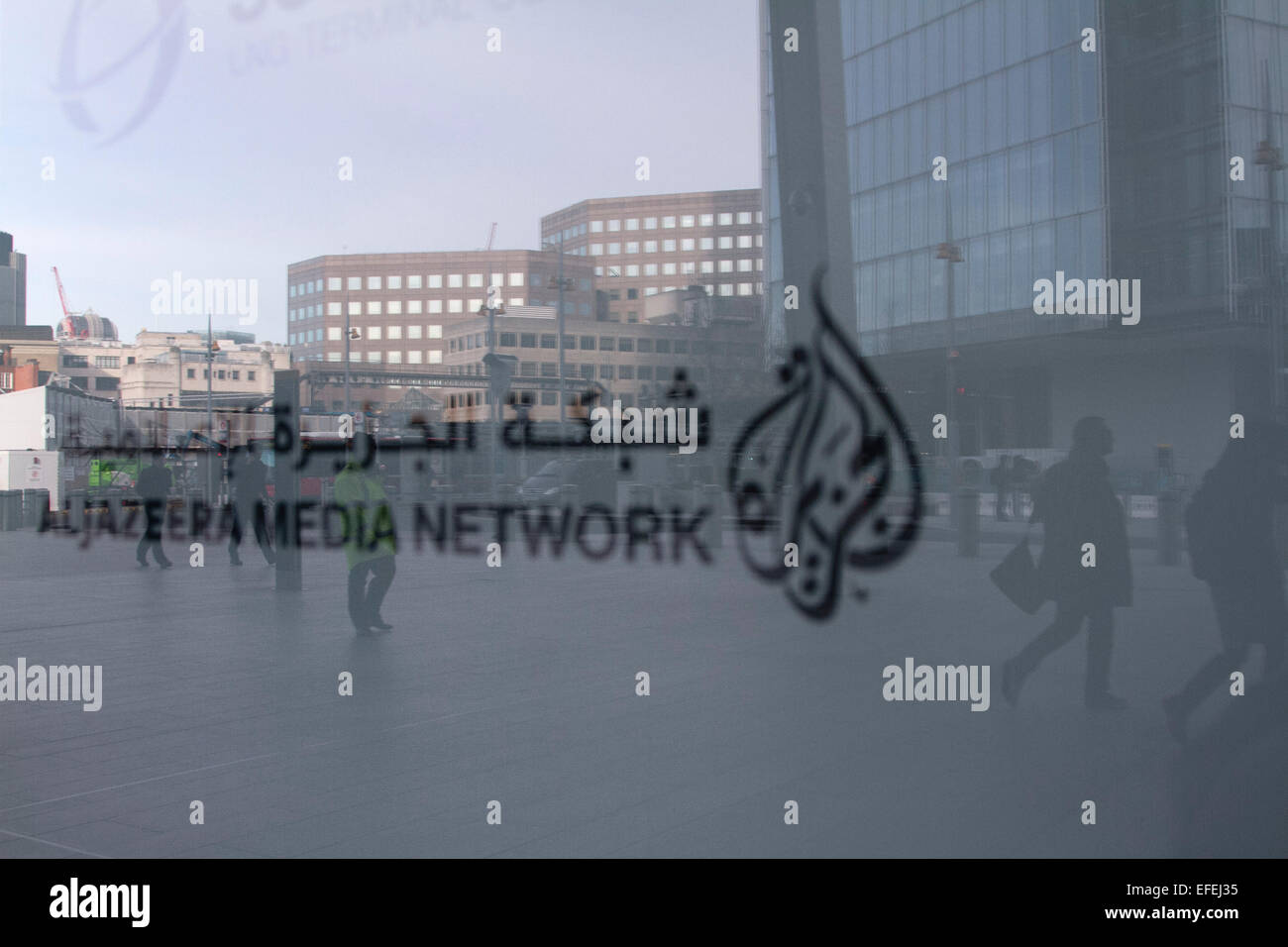 London, UK. 2nd February 2015. Pedestrians reflected on the window of the  broadcasting media office of AlJazeera in London after Al Jazeera journalist Peter Greste was freed and deported from Egypt. Credit:  amer ghazzal/Alamy Live News Stock Photo