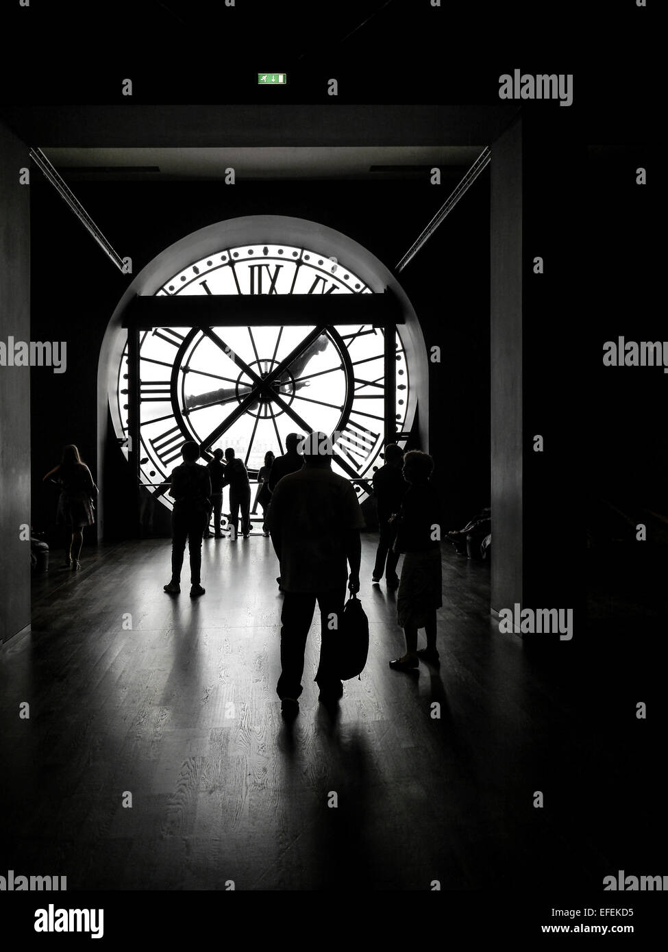 Silhouettes of tourists visiting d'Orsay Museum shot against big external clock Stock Photo