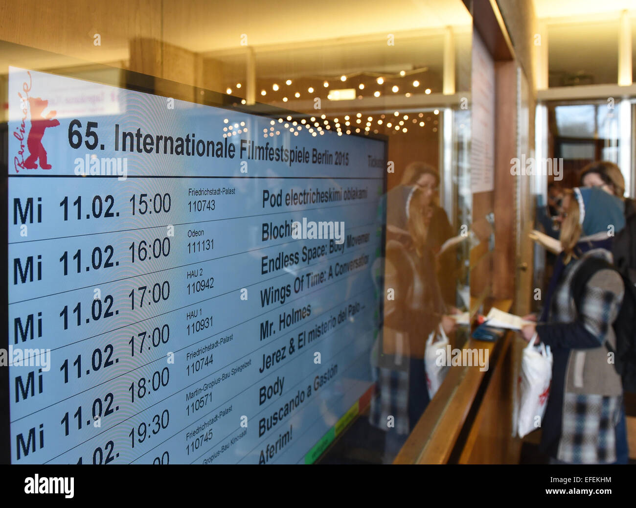 Berlin, Germany. 02nd Feb, 2015. Movie buffs stand online next to a screen displaying the Berlinale films they can get tickets for at a ticket booth at Kino International in Berlin, Germany, 02 February 2015. Berlinale tickets are on sale in advance at four different locations in Berlin. The 65th Berlinale International Film Festival takes place from 05 to 15 February 2015. Credit:  dpa picture alliance/Alamy Live News Stock Photo