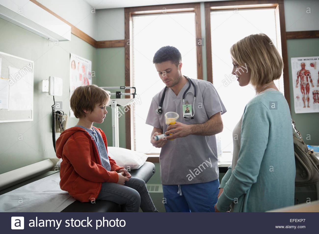 Male nurse explaining inhaler to boy Stock Photo
