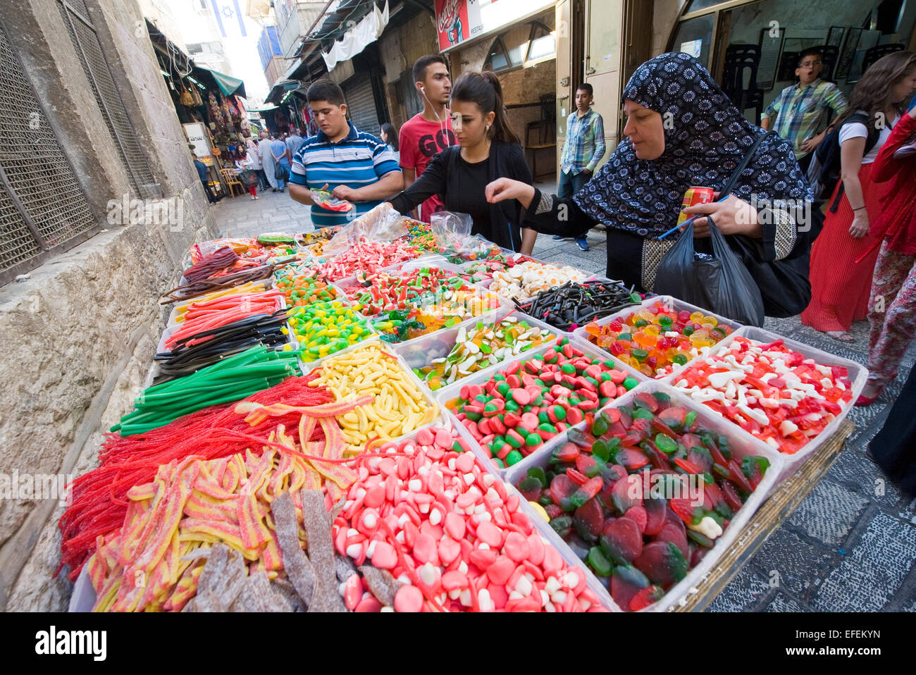 Woman are watching and buying sweets at a candy store in one of the small streets in the old city of jerusalem Stock Photo