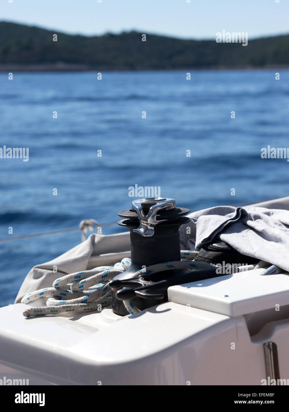 Rope winch detail on sailboat with island in background Stock Photo