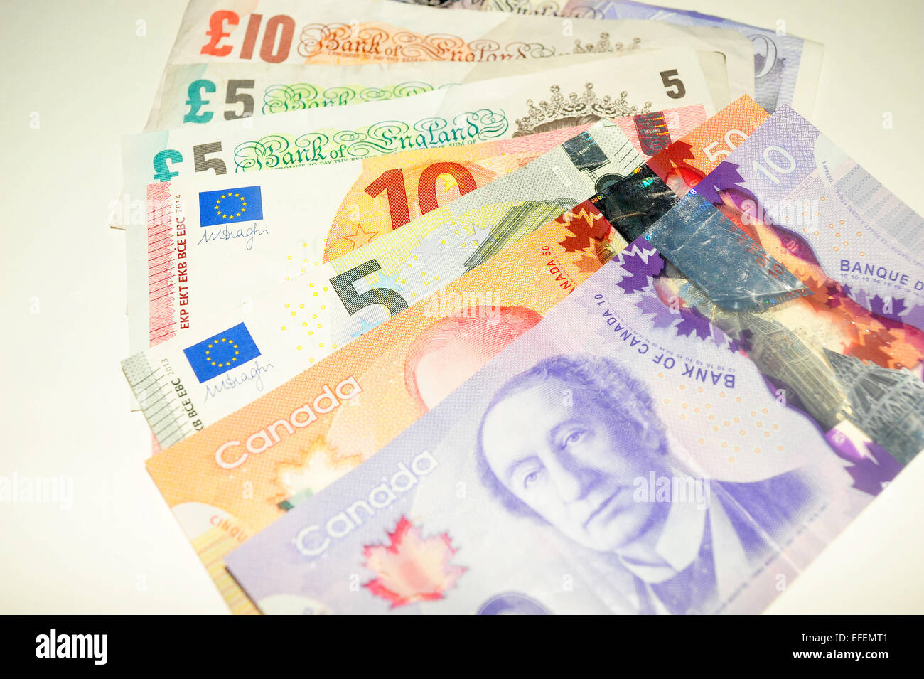 British Pound notes, Canadian Dollar notes and European Euro notes photographed against a white background. Stock Photo