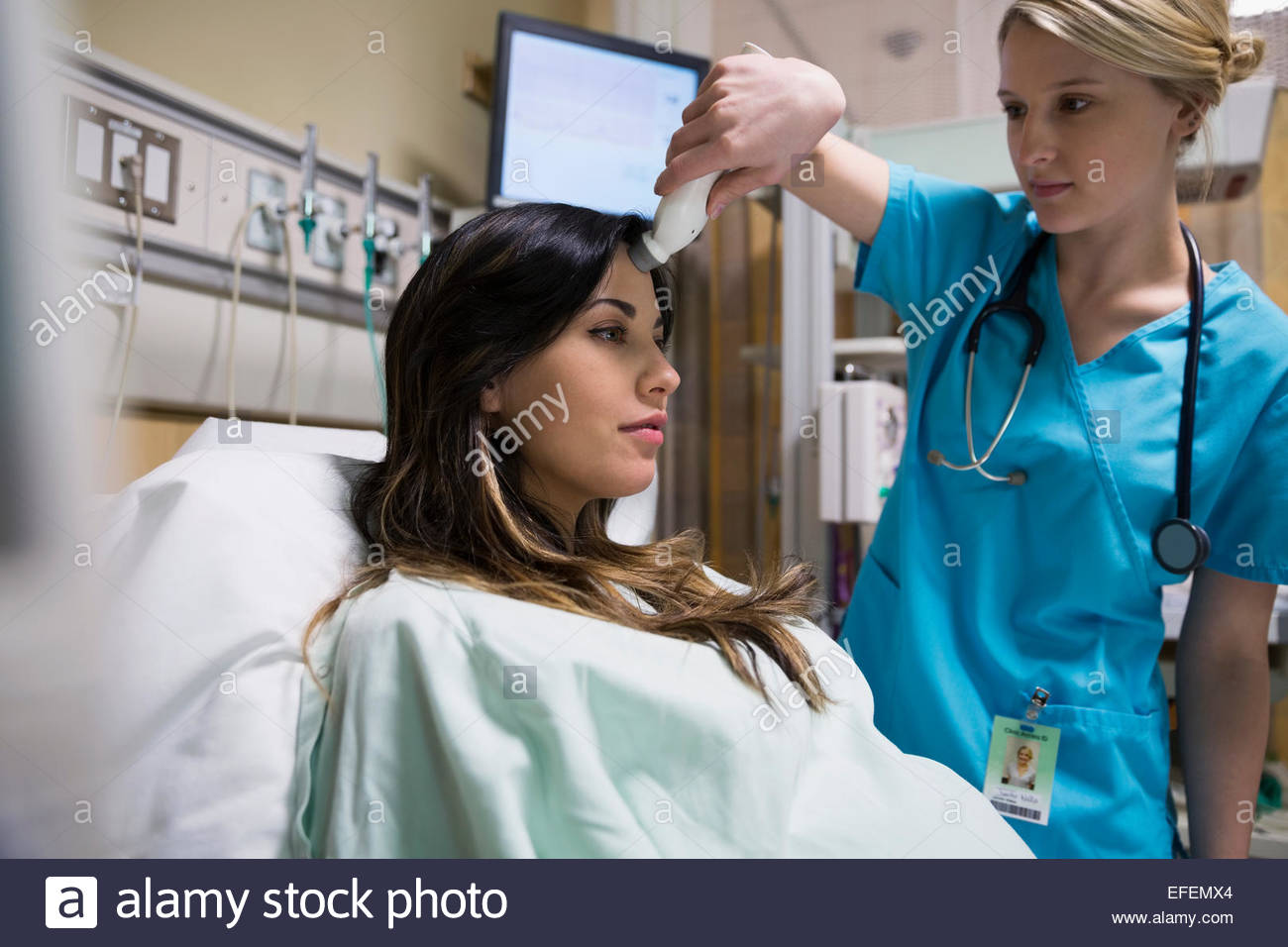 Nurse using forehead thermometer on pregnant woman Stock Photo