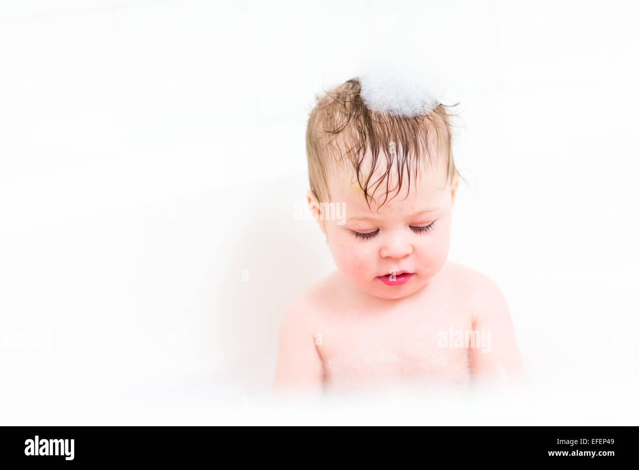 Cute baby girl taking a bath with bubbles Stock Photo Alamy