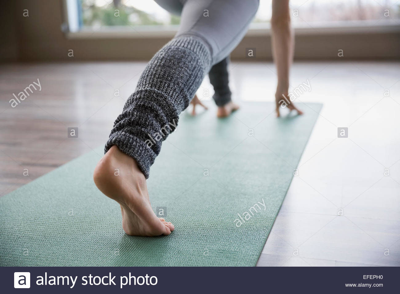 Woman practicing yoga in lunge pose on mat Stock Photo