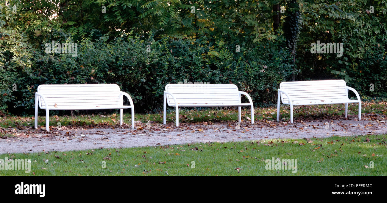 Row of three white park benches, three benches in a line, Arlem, Germany Stock Photo