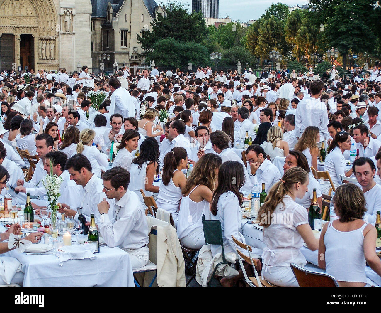 Paris, France. 16 Jun 2005 - Hunderds of people gather as a large crowd for the 17th 'Diner en Blanc' (Dinner in White), outside the Notre Dame cathedral. Invited guests know when the dinner will be, but not the location, which is only revealed on the day of the event. Its aim is to raise funds for cancer charities. Stock Photo