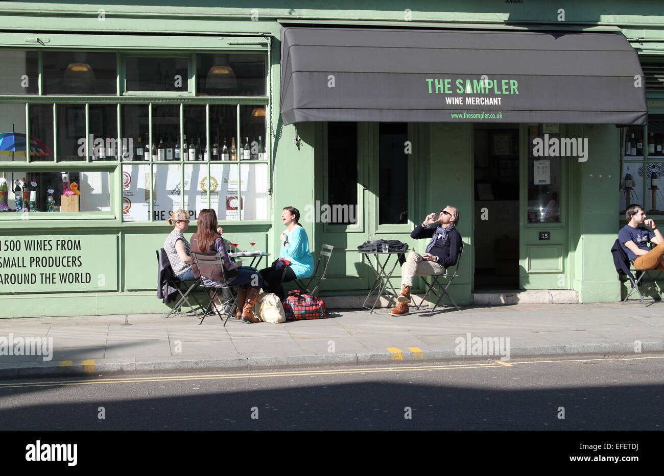 People sitting outside wine bar drinking and enjoying early spring
