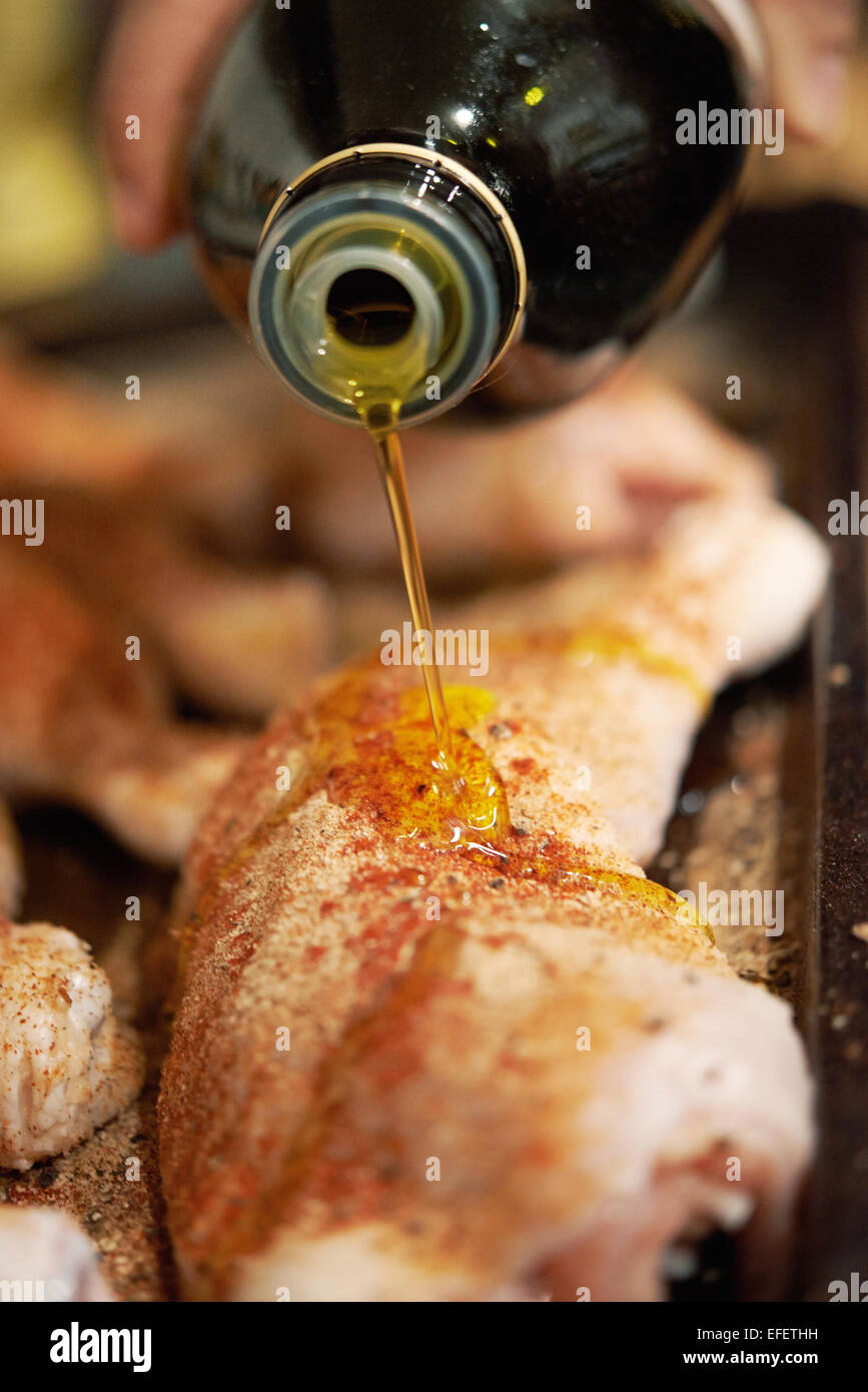 Chicken being prepared with olive oil and seasonings Stock Photo