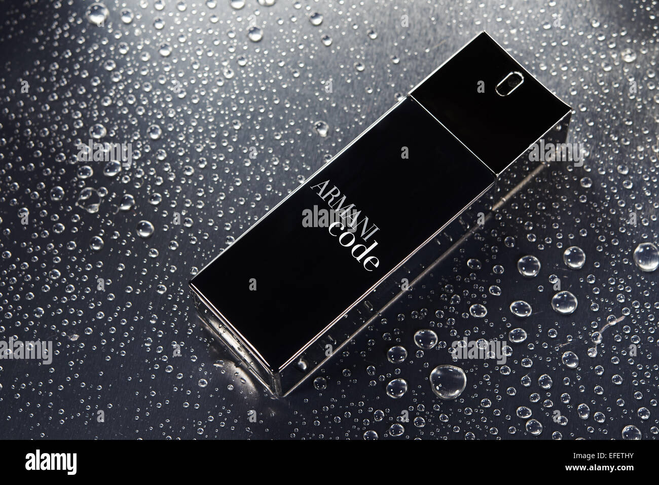 Armani Code black bottle sitting on water droplets Stock Photo