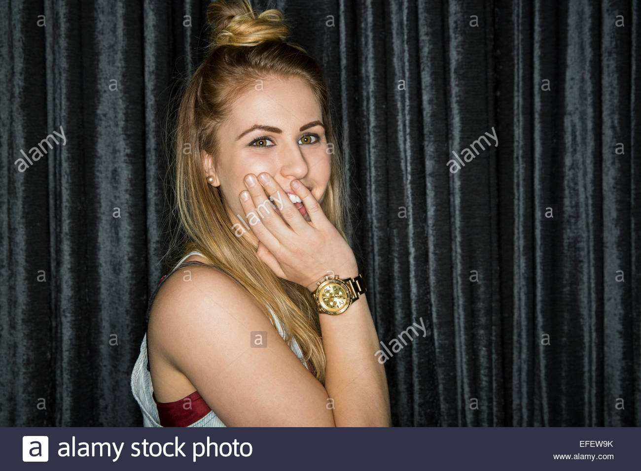 Portrait of smiling blonde woman covering mouth Stock Photo - Alamy