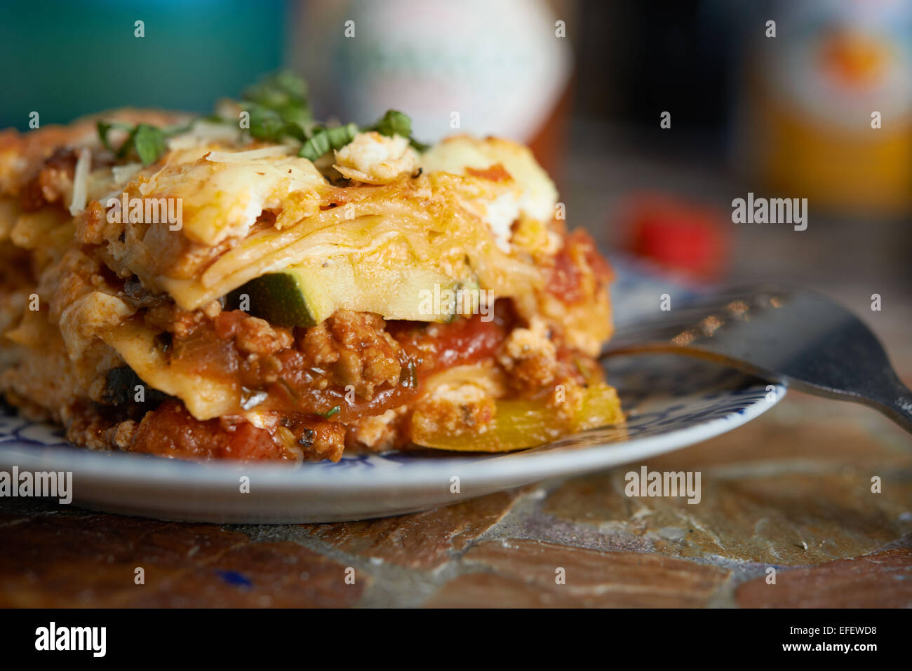 Lasagna sitting on a plate with a fork sticking out. Food Photography. Sid View Stock Photo