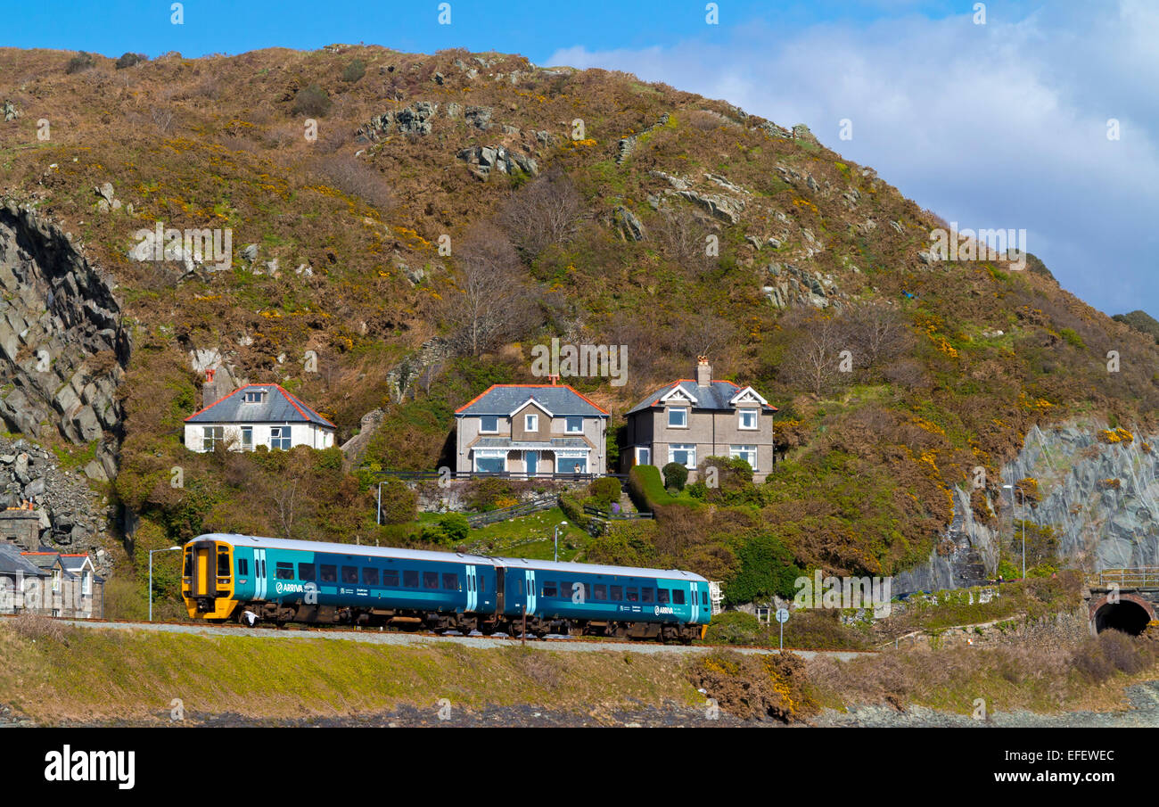 Arriva passenger train approaching Barmouth on the Mawddach Estuary in Gwynedd North Wales UK built in 1867 Stock Photo