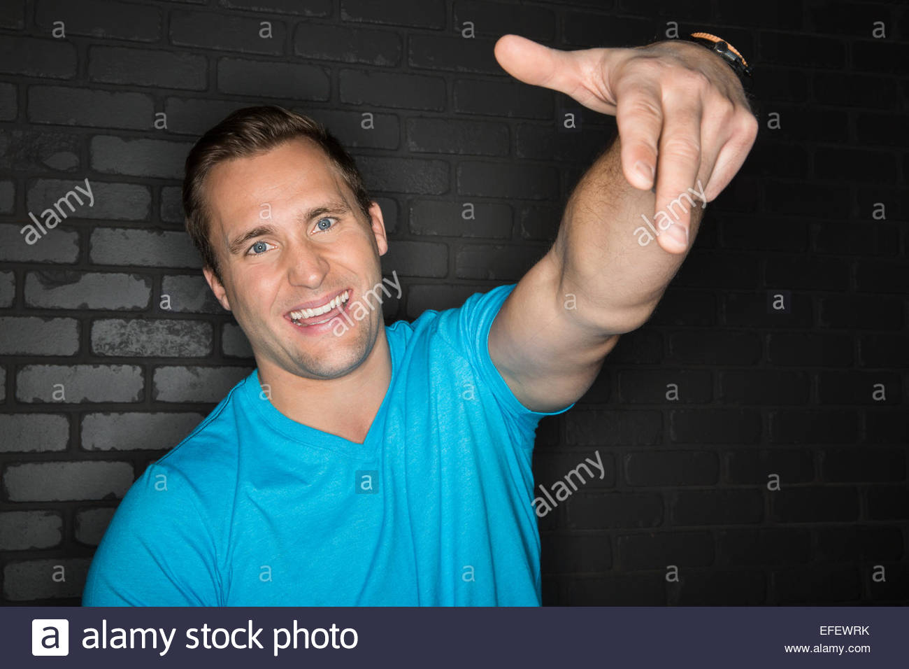 Portrait of cool man in blue shirt gesturing Stock Photo
