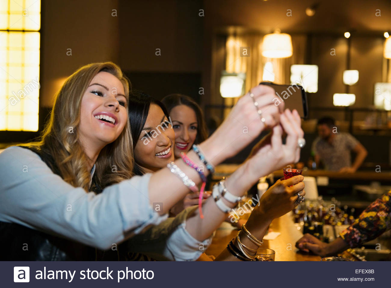 Smiling women taking selfie at bar Stock Photo Alamy