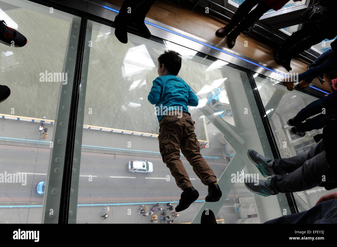 Visitors on  the new glass floor in Tower Bridge. One of the bridge’s new £1 million glass-bottomed walkways. Stock Photo
