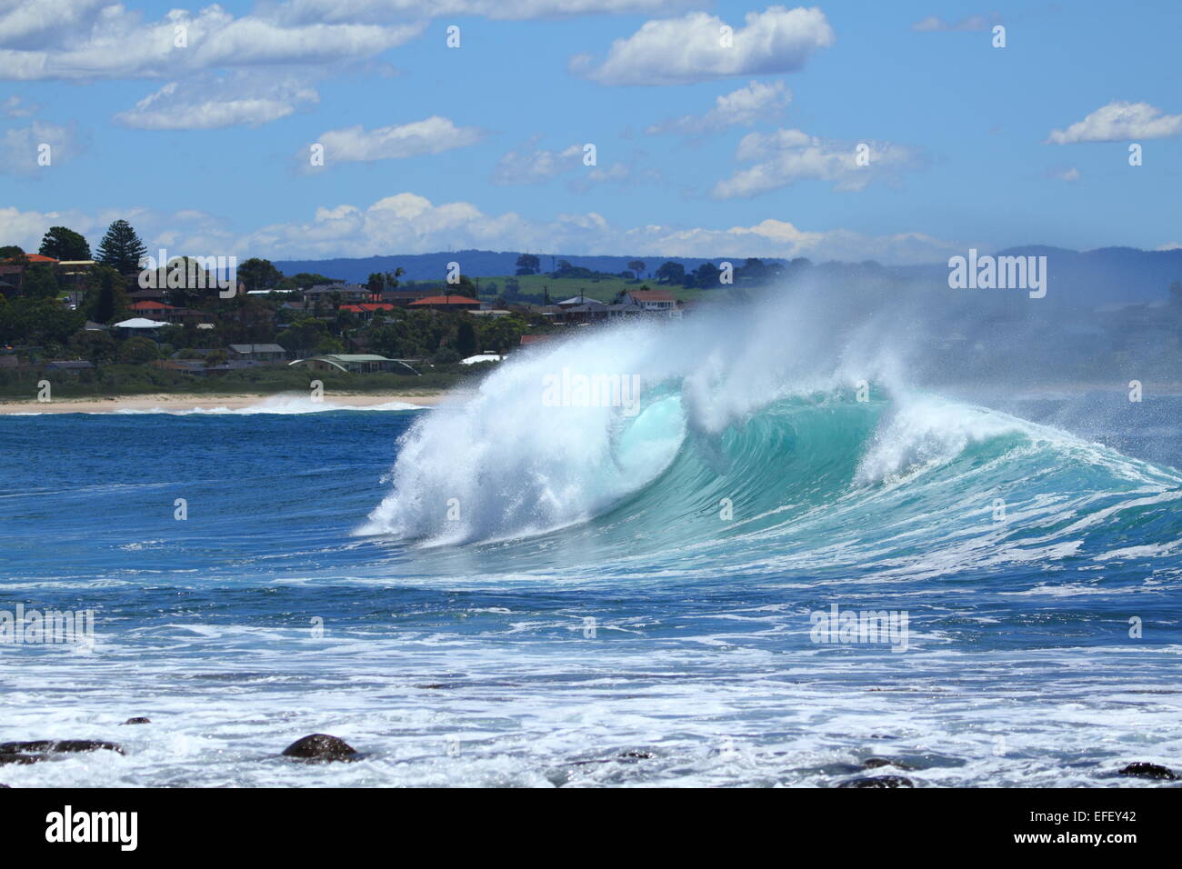 A large Pacific Ocean wave curls and breaks at The Boneyards surf break