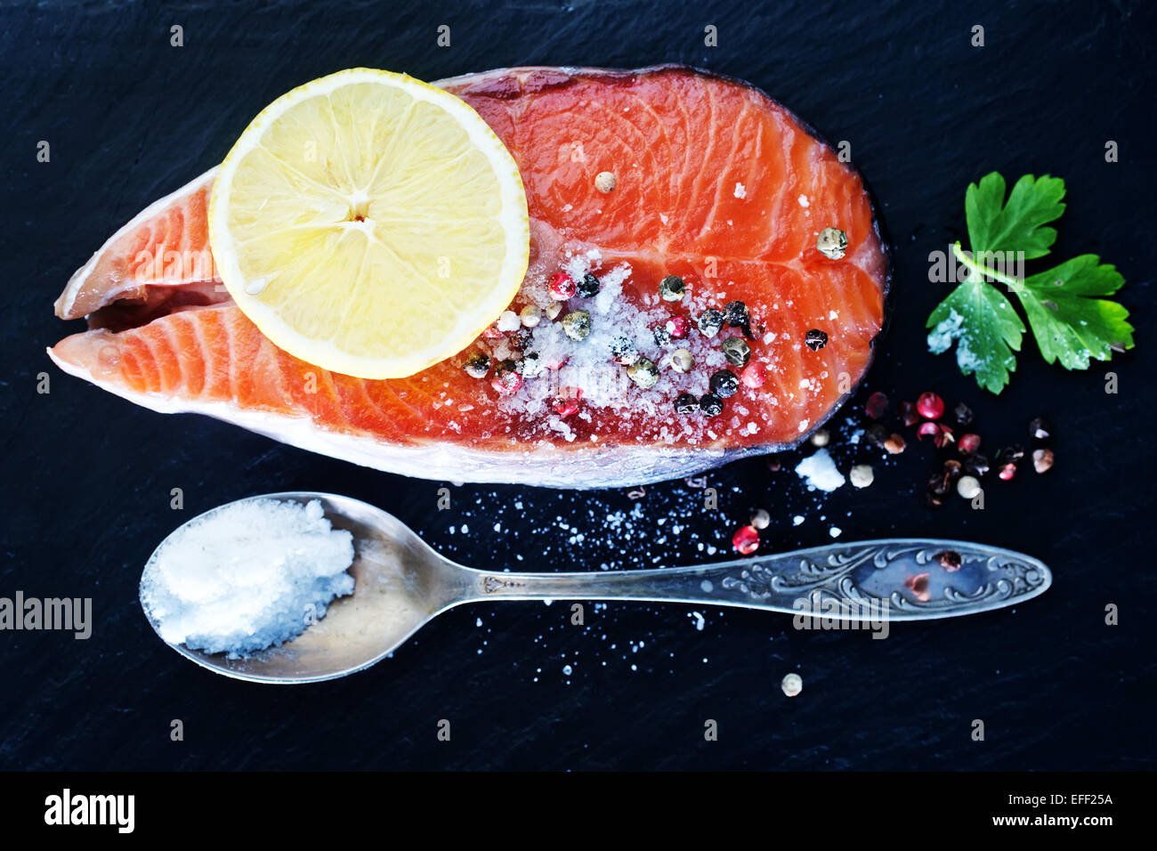 raw salmon steak with spice on the black board Stock Photo - Alamy